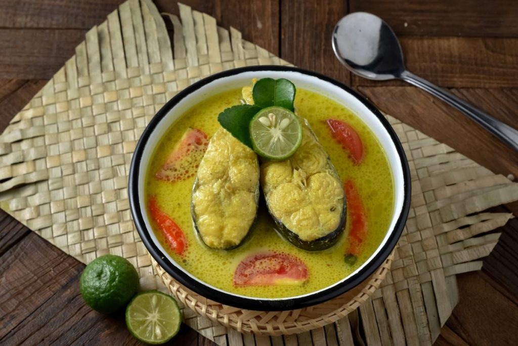 Ikan bumbu kuah kuning gurih dengan tomat dan daun kemangi.