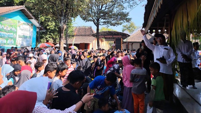 Warga mengikuti tradisi tebar koin Maulid Nabi di Masjid Al-Ishaq Desa Coper Ponorogo